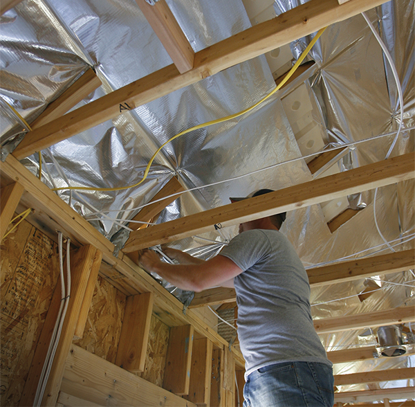 A man on a ladder installs RadiaSource installation