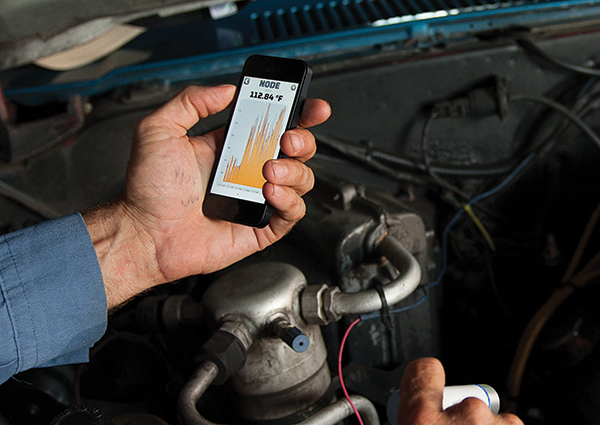 Mechanic using diagnostic tool on car engine