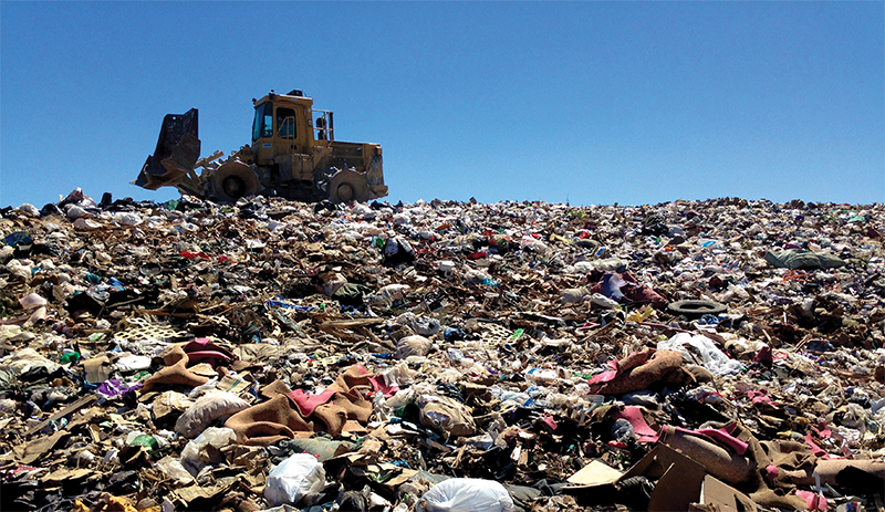 Bulldozer atop a garbage pile