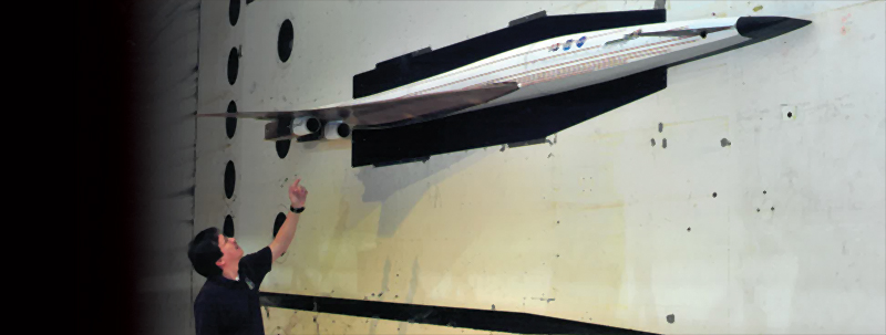 Aeroelasticity engineer Walt Silva examining an aircraft model in a wind tunnel