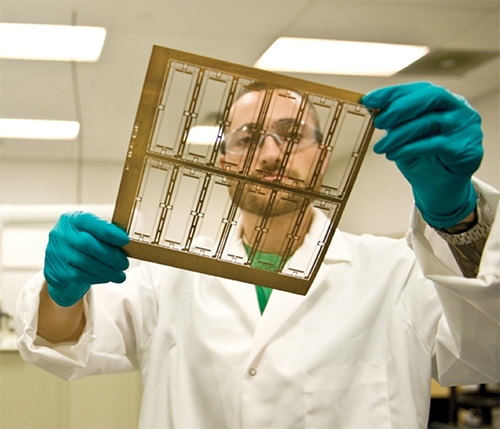 A Mikro Systems Inc. employee holds a layer of a TOMO tool.