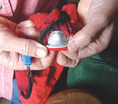 A look at the silver reflective material that is sewn into a pair of red gloves