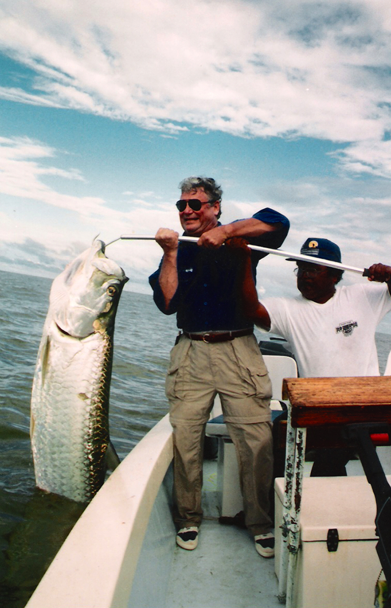 Fishermen on a boat with a very large fish on the hook