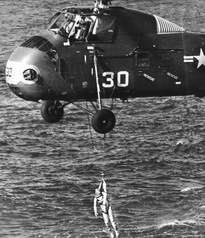 A helicopter lifts astronaut Gus Grissom to safety.