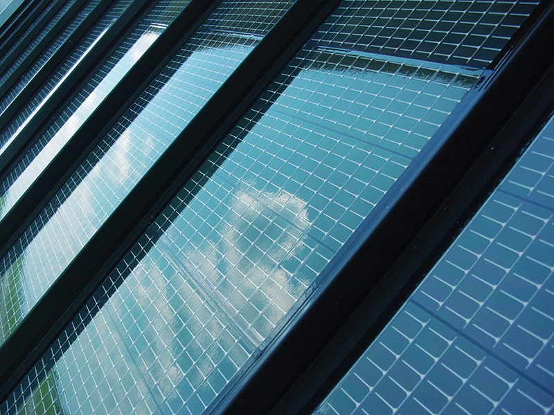 A picture of solar cells reflecting the clouds in the sky