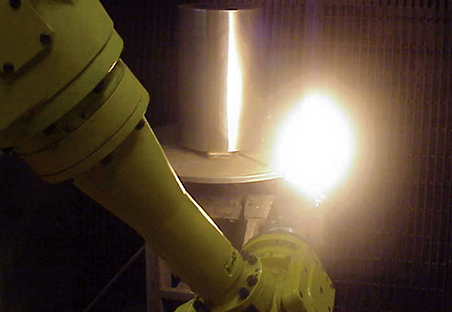 A spray gun applies a nano coating to a steel roller