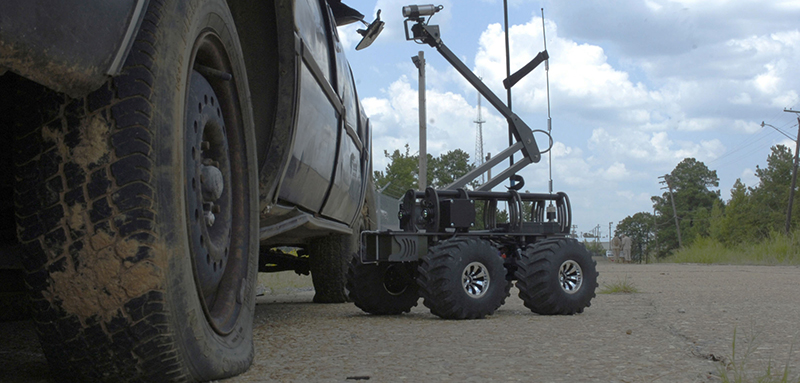 The MARCbot examines a vehicle.