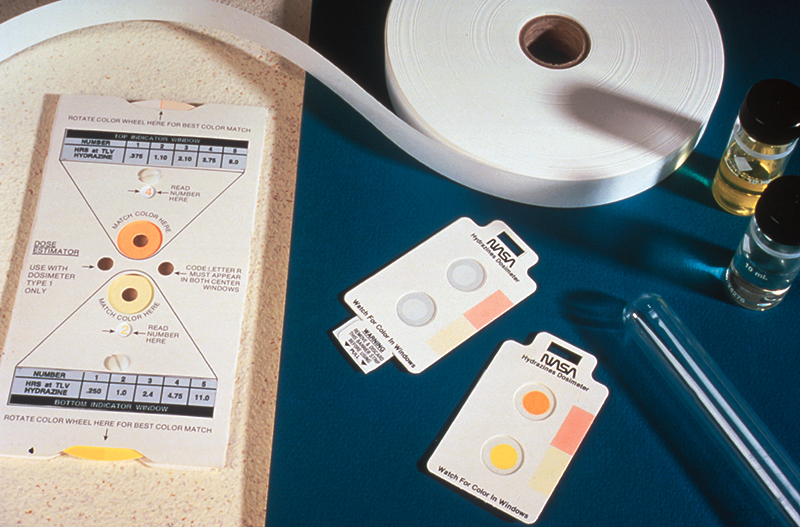 Two Hydrazine badges show the reaction when exposed to hydrazine, the badge has turned orange and yellow