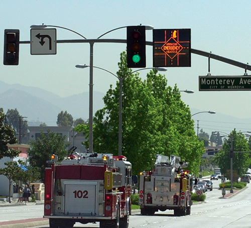 Emergency vehicles crossing intersection with LED displays above