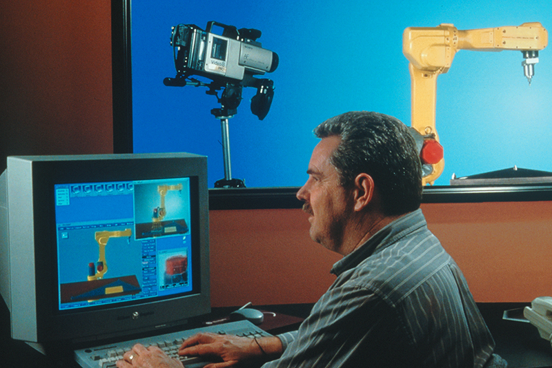 A video camera provides a Deneb engineer with a view of the robot