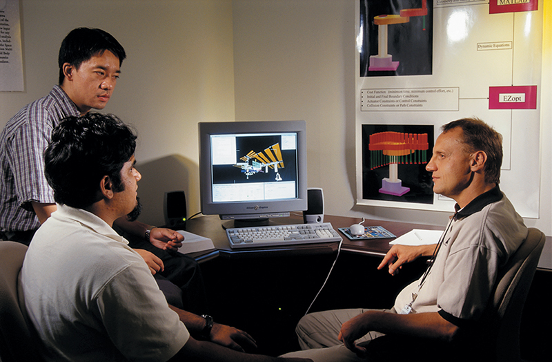 Dr. Hans Seywald discusses the EZopt program with other team members as it runs a trajectory analysis for space station simulations