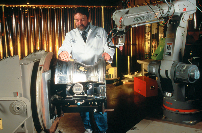 A Rocketdyne technician inspects welds on the Space Shuttle Main Engine