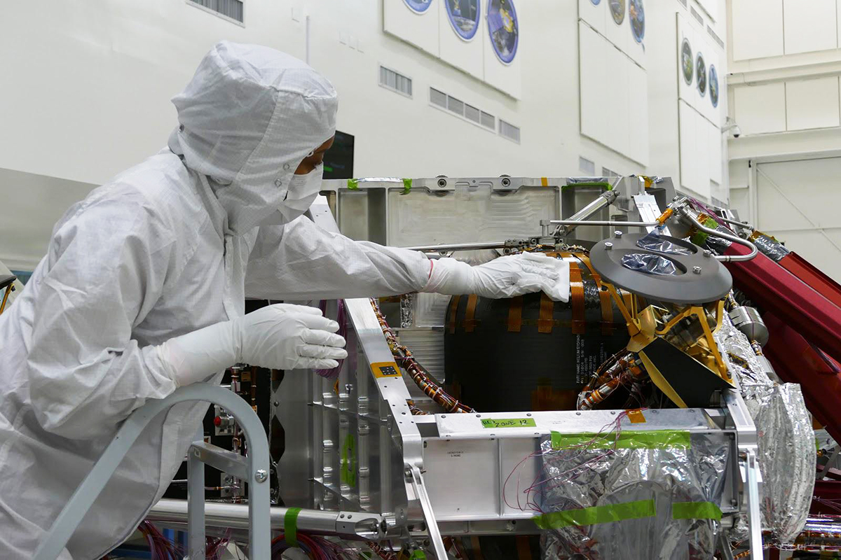 A technician wipes down the hardware of the Perseverance rover in NASA’s Jet Propulsion Laboratory cleanroom