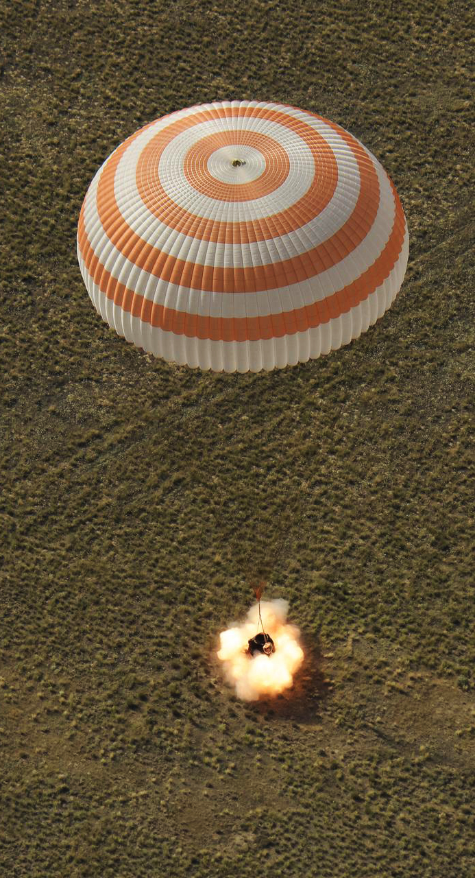 A Soyuz capsule landing with parachute