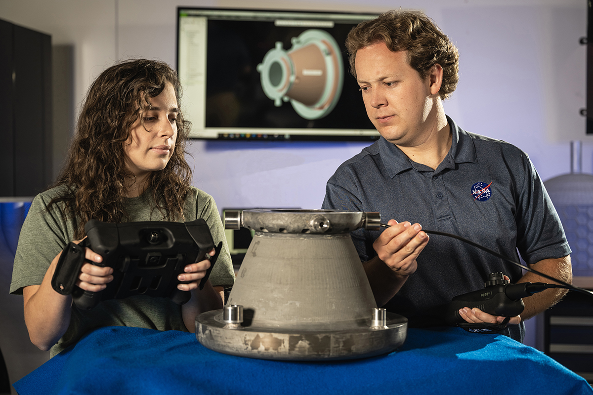 NASA engineers Tessa Fedotowsky and Ben Williams inspect a 3D printed aluminum nozzle