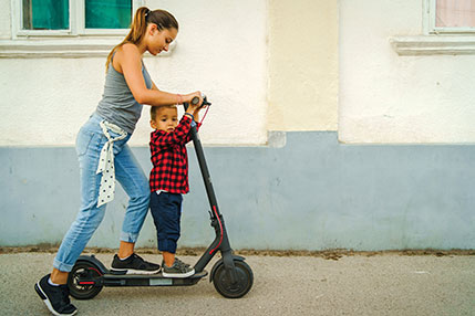 A woman and a child  on an electric scooter