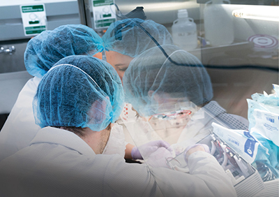 Two SpaceLab technicians in protective gear prepare a CubeLab experiment