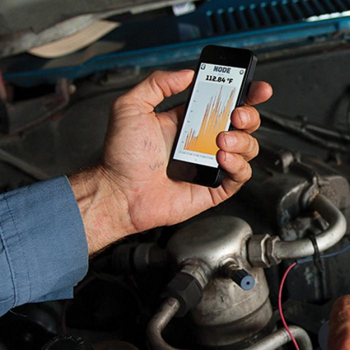 Mechanic using diagnostic tool on car engine