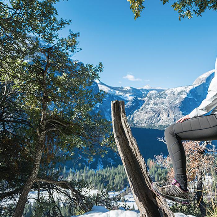 A woman on a mountain trail wearing Oros aerogel-lined outerwear