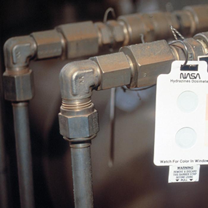 Badge hung on a pipe for use as a low-cost leak detector