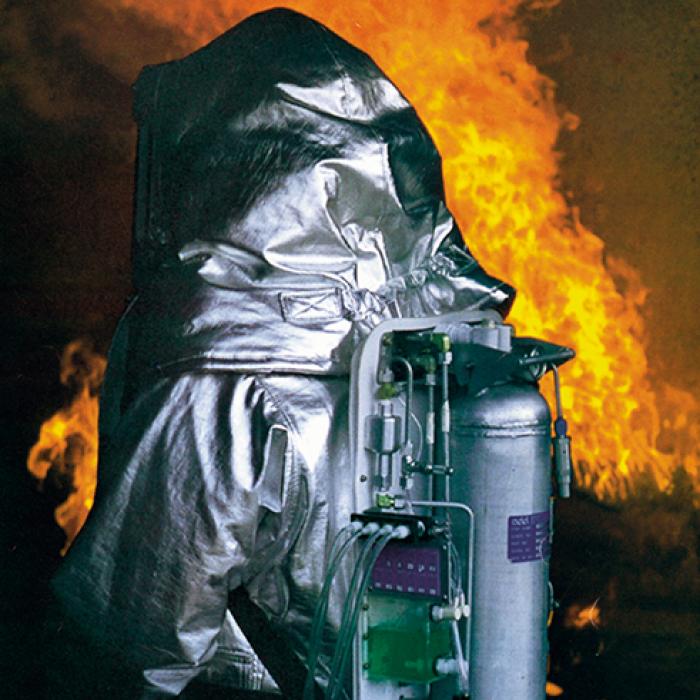 A person surrounded by flames wearing SCAMP, a self-contained breathing apparatus