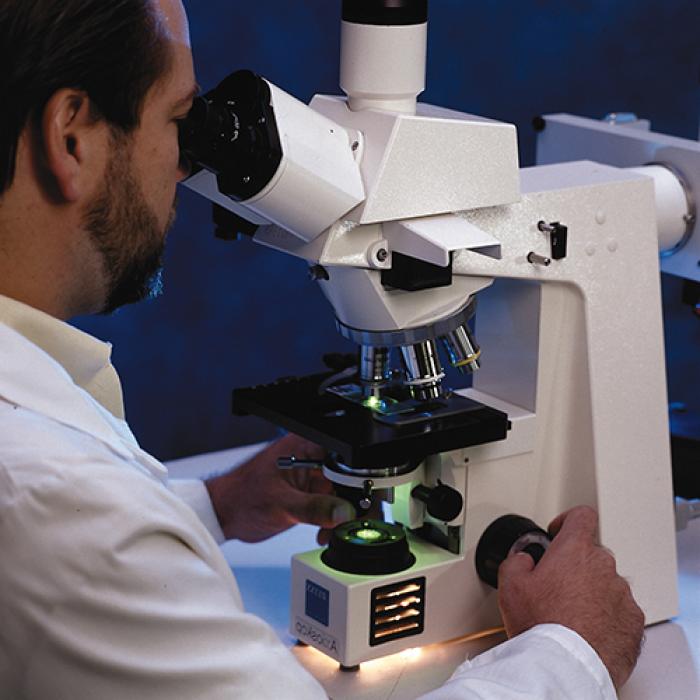 Researcher looks through an automated chromosome analyzer that uses the PowerGene system