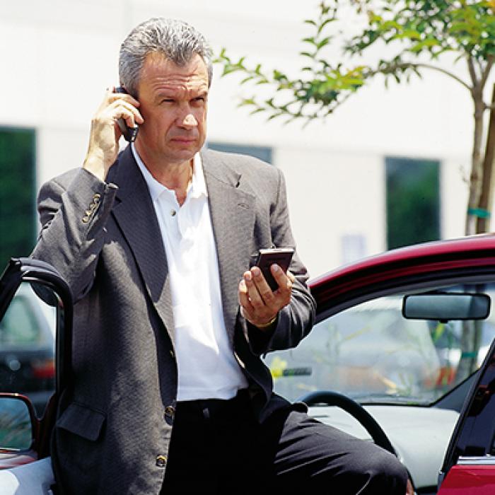 A man using the web time-management tool from his parked car