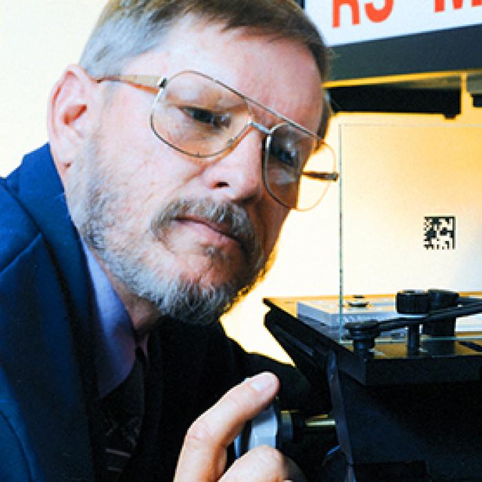 A man inspects laser-applied product labeling