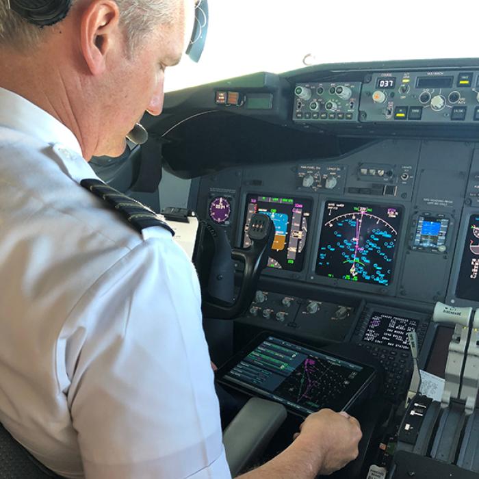 Alaska Airlines Captain Bret Peyton looks at route options presented on a tablet called an electronic flight bag
