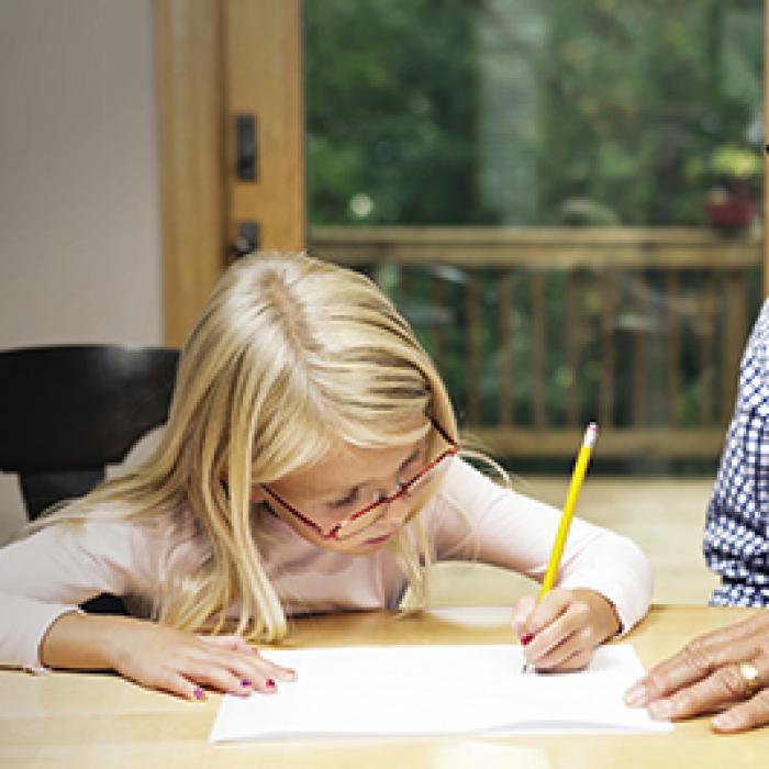 Man helping granddaughter with homework