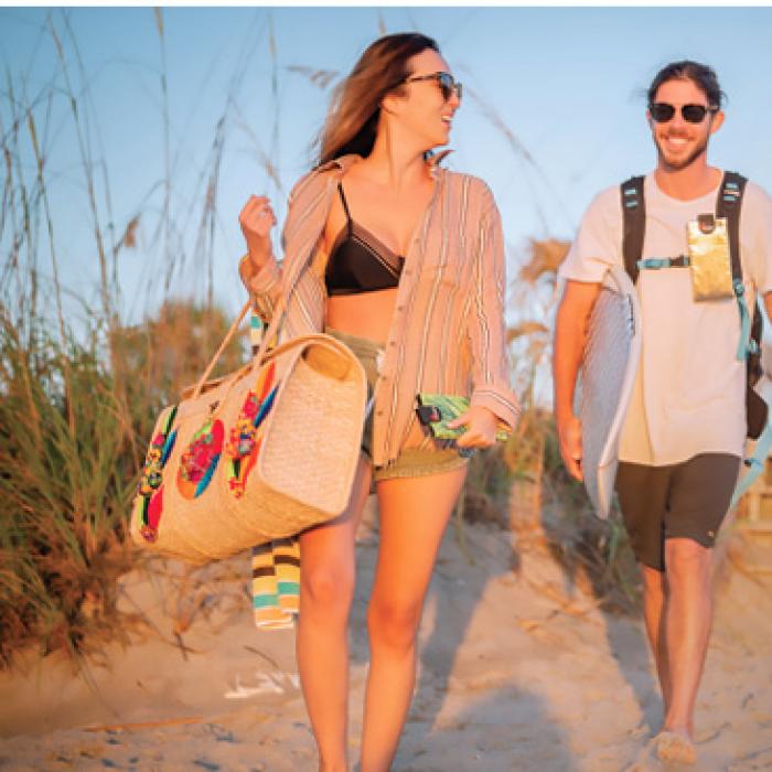 Two beachgoers carrying Phoozy insulated smartphone cases