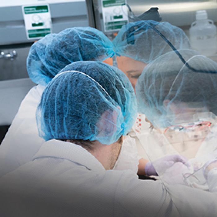 Two SpaceLab technicians in protective gear prepare a CubeLab experiment