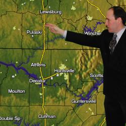 A meteorologist interacts with a map