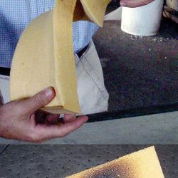 A man’s hands bend Polyshield foam, showing its flexibility, and a torch is applied to show its thermal strength 