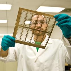 A Mikro Systems Inc. employee holds a layer of a TOMO tool.