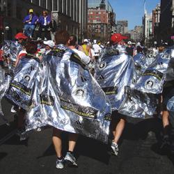 Marathon runners draped in reflective blankets to keep them warm