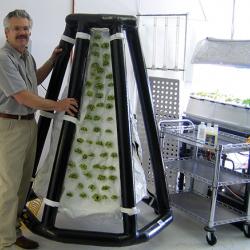 Richard Stoner II, the president of Agrihouse, next to an inflatable plant system