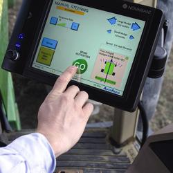 A farmer uses a touch screen console mounted on his tractor to control Auto steer