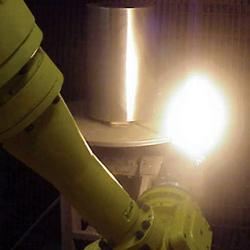 A spray gun applies a nano coating to a steel roller