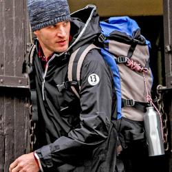 A hiker wears a 13-One jacket