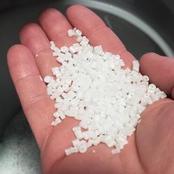 Tiny pellets of Okhata aerogel-infused plastics held in a person's hand