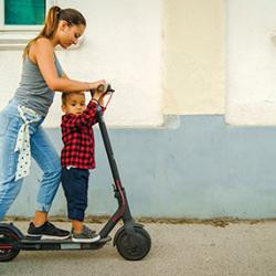 A woman and a child  on an electric scooter